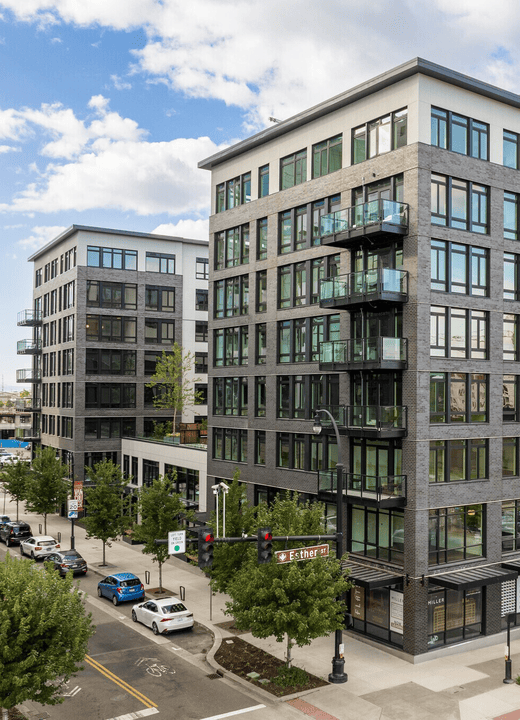 8-story residential building with ground floor retail at day